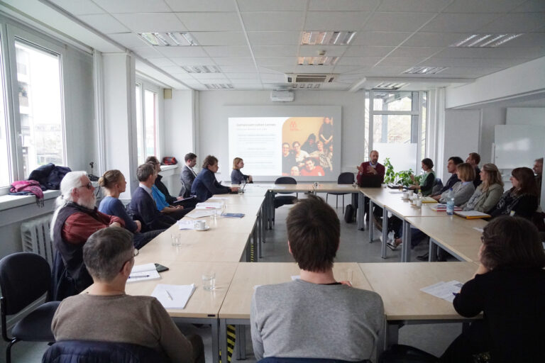 Versammlungtisch mit vielen Menschen, Szene aus Workshop